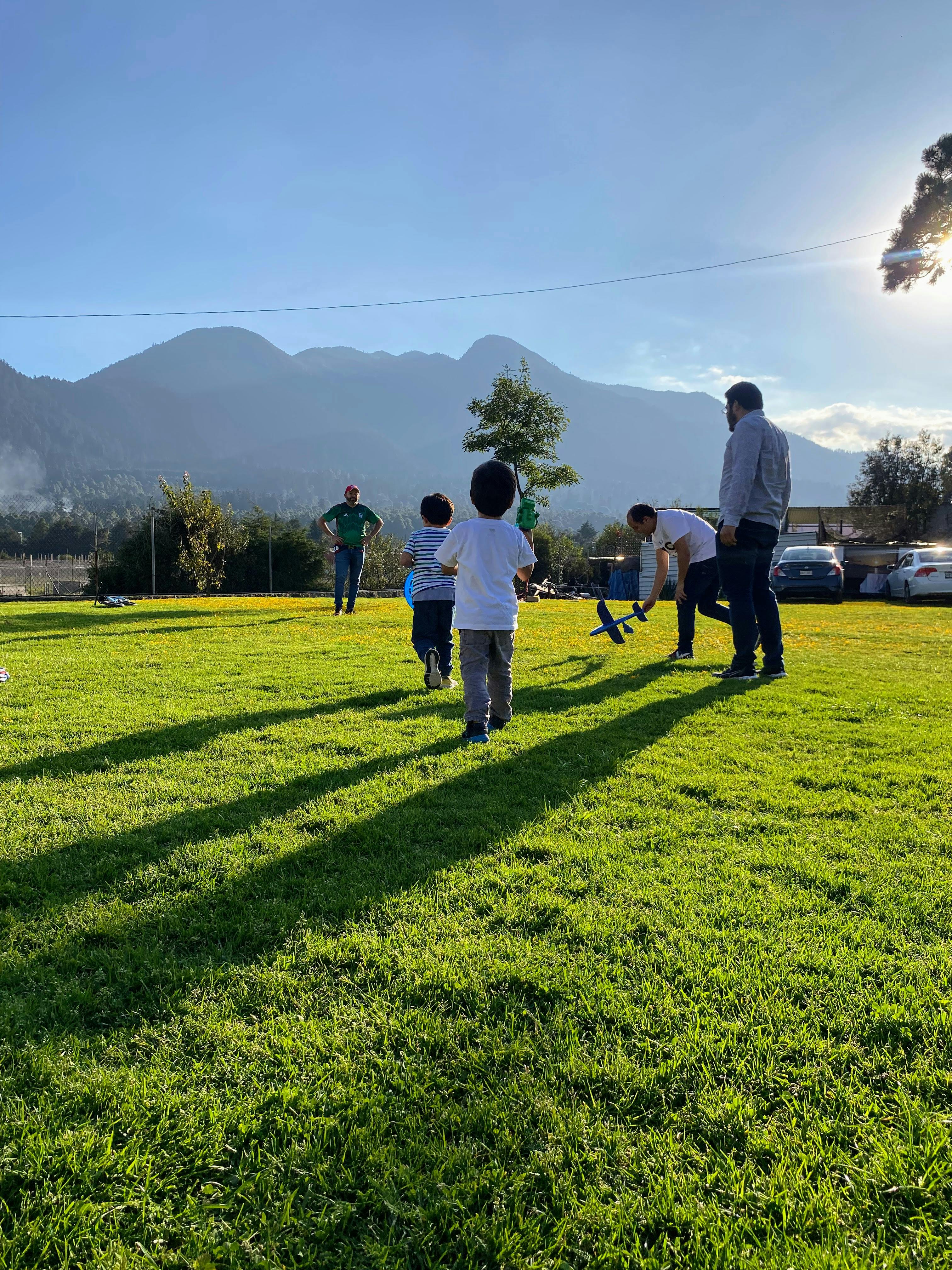 Fotografía de mis sobrinos jugando previo al atardecer en un patio muy grande.