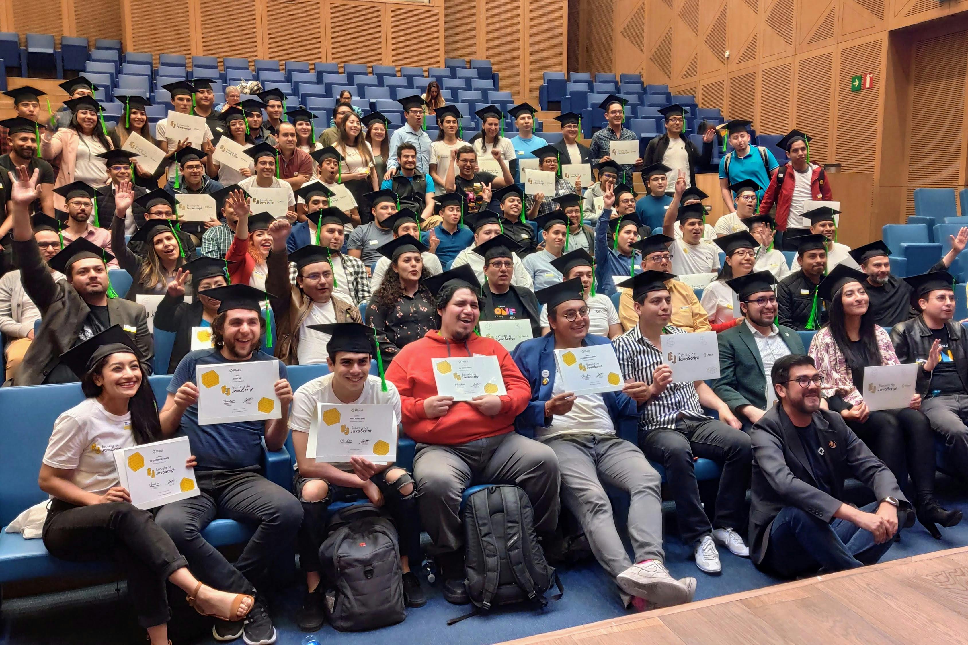 Fotografía de todos los graduados de la Escuela de Javascript sosteniendo su diploma. 