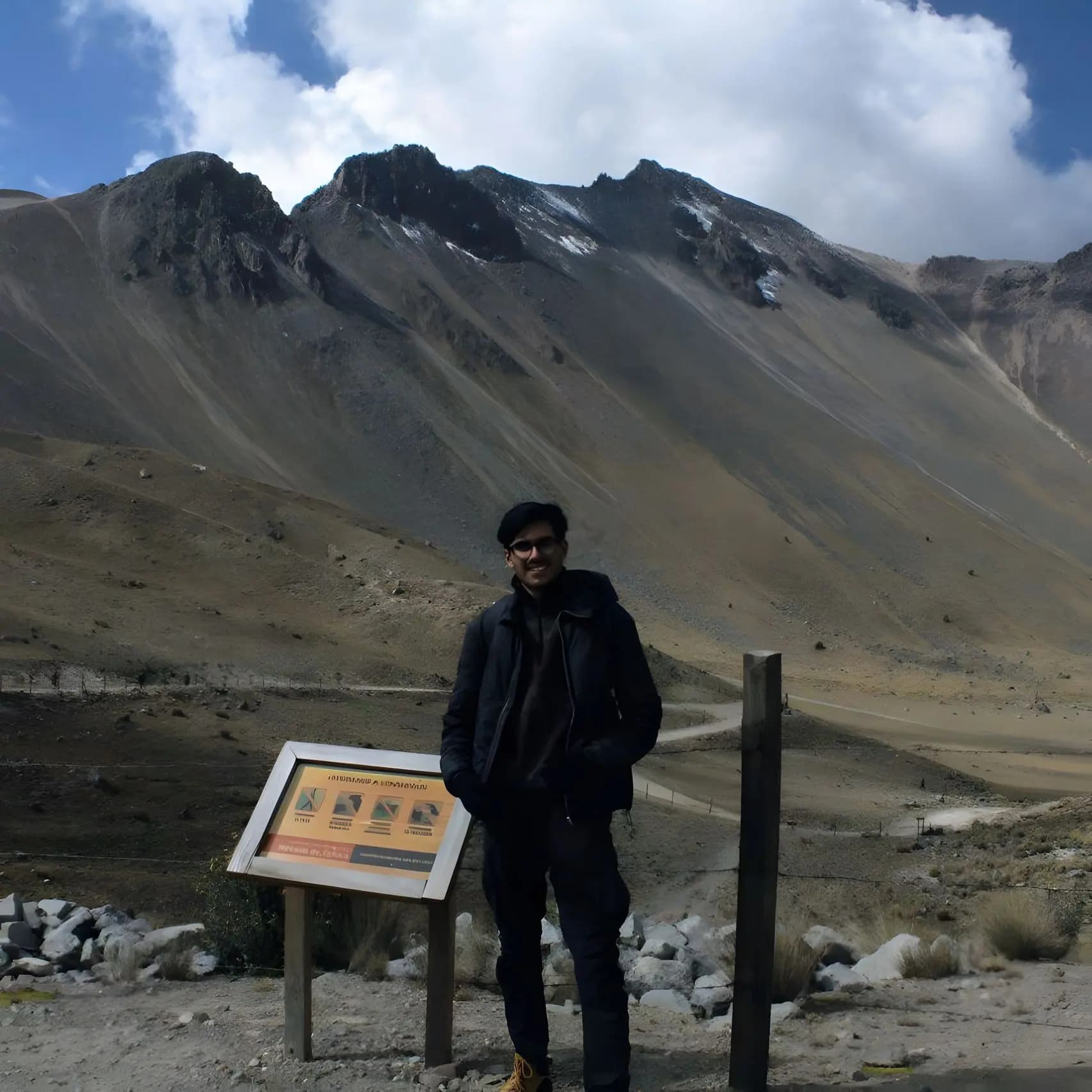 A full-body photograph of me with large mountains in the background.