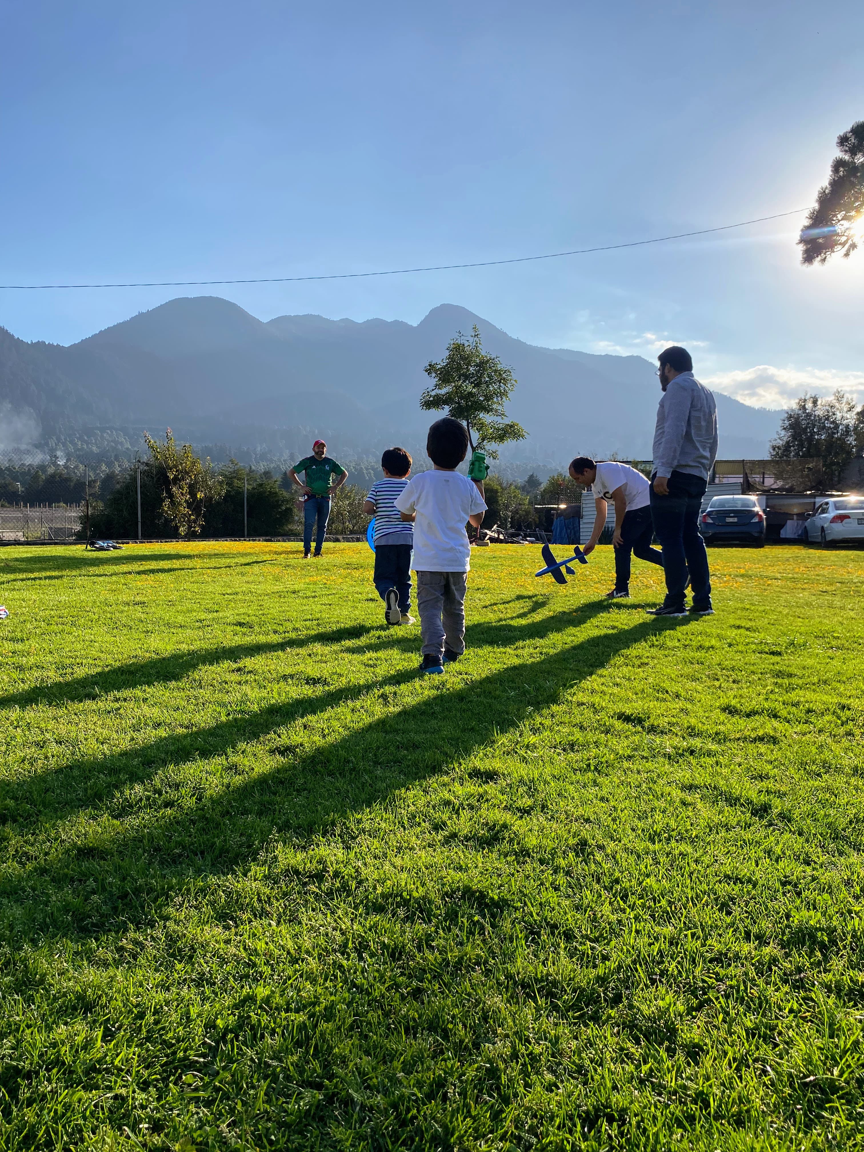 A photograph of my nieces and nephews playing in a large backyard just before sunset.